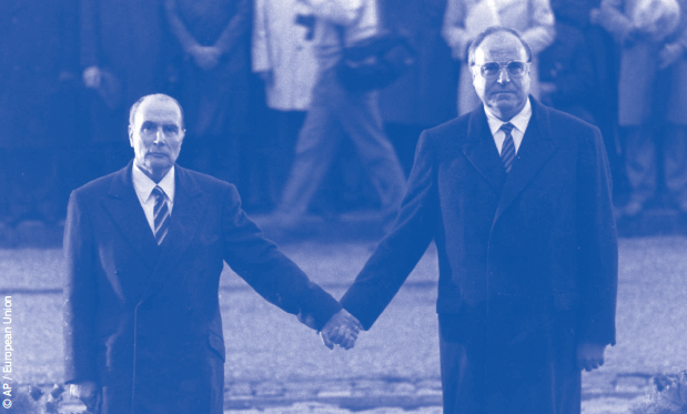 President Mitterrand and Chancellor Kohl standing hand in hand in front of a memorial wreath at the Douaumont Ossuary, Verdun in 1984.
