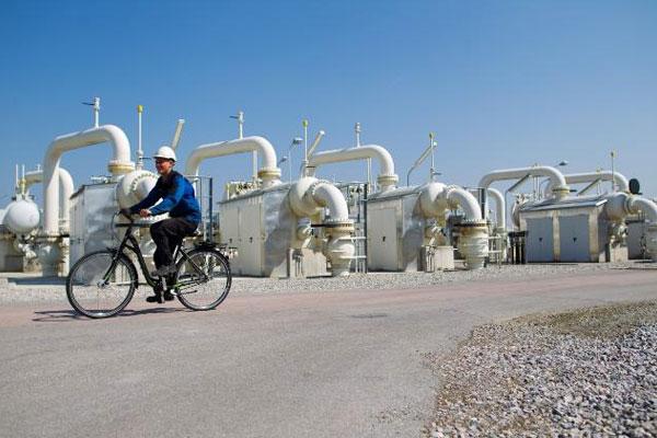 A staff member on a bicycle passing by filter separators used for natural gas cleaning © EU