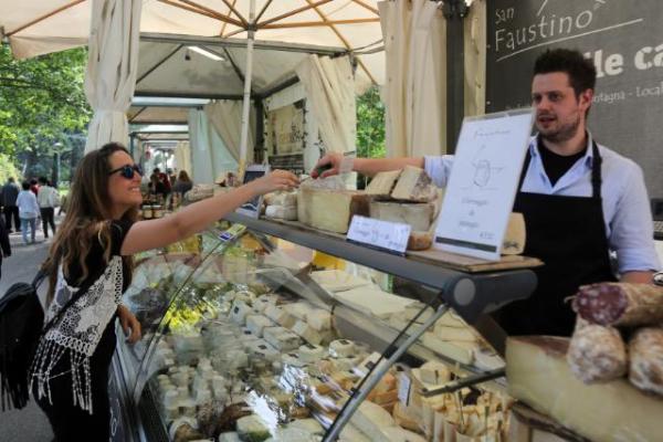 An Erasmus student tasting cheese on a market