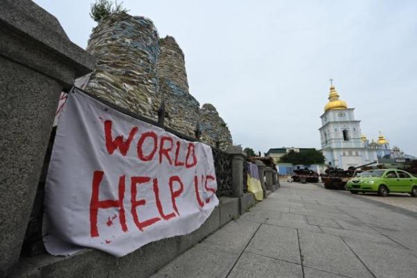 A banner reading "World help us" displayed on the covered and protected Monument to Princess Olga
