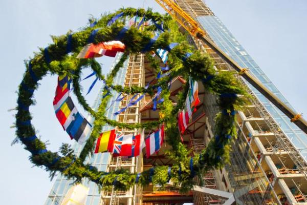Flags of the European Union member states are seen on the topping-out wreath as it is hoisted by a crane