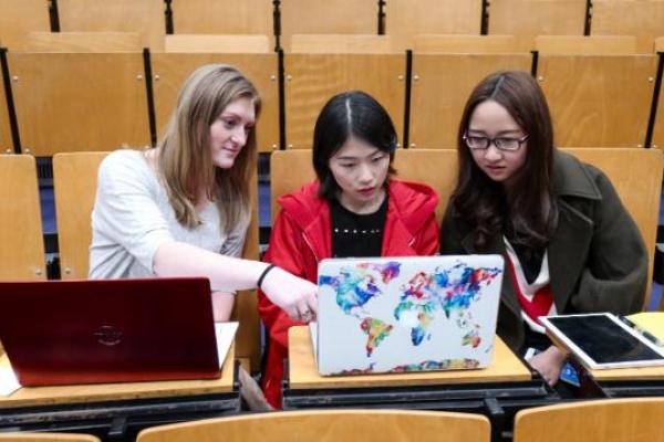 Monica Kathleen Leedle, American student, Zhou Jong and Li Xueying, Chinese students, working on a laptop (from left to right)