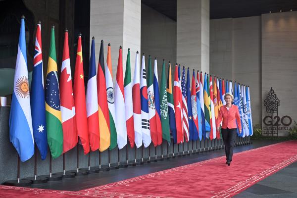 Ursula von der Leyen walking past flags at the G20