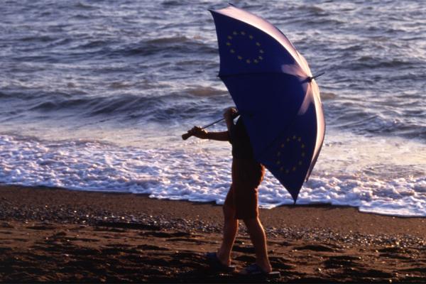 Child with a European umbrella at the beach