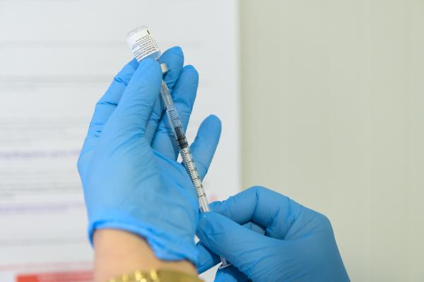 A nurse filling a syringe with a dose of the COVID-19 vaccine