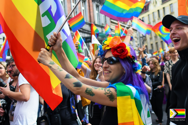 Crowd of smiling people with rainbow flags
