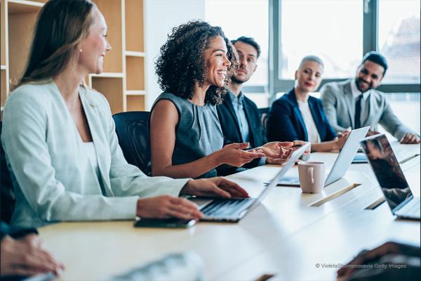 A women leading a meeting with women and men around the table
