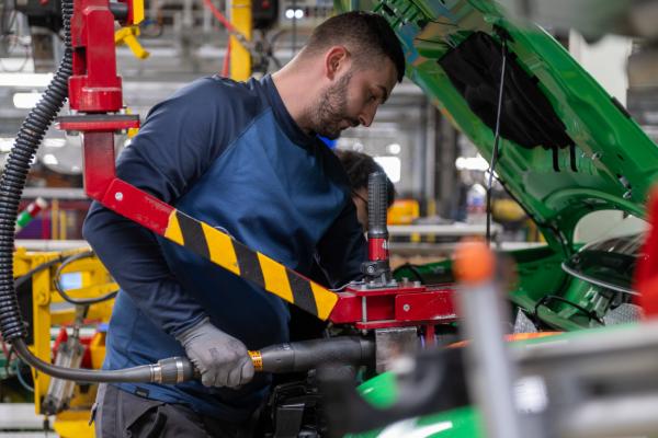 A man working on a green car