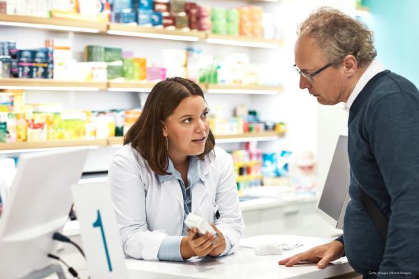 Confident chemist explaining medicine to customer