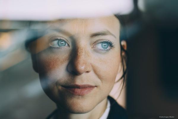 Female executive looking away seen through glass at workplace