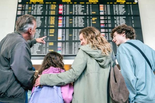 Family look at airport timetable in terminal