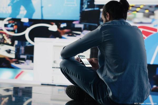 Sitting man looking at his smartphone