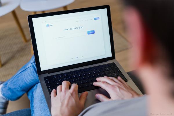  Person typing on a laptop using an AI chatbot assistant