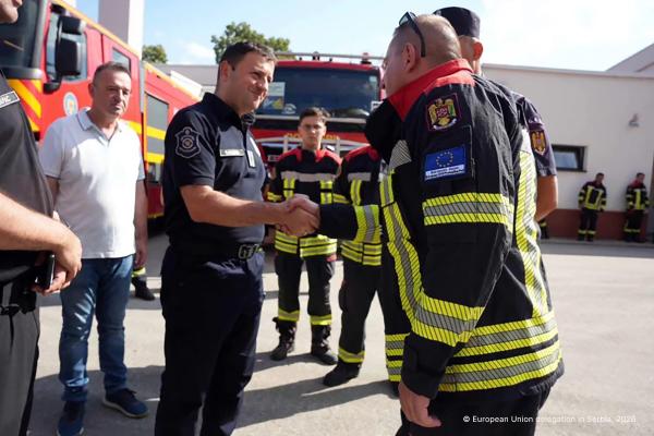 Firefighters greet each other on the ground in Serbia