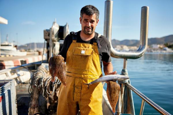 Fisherman holding up a fish in both hands